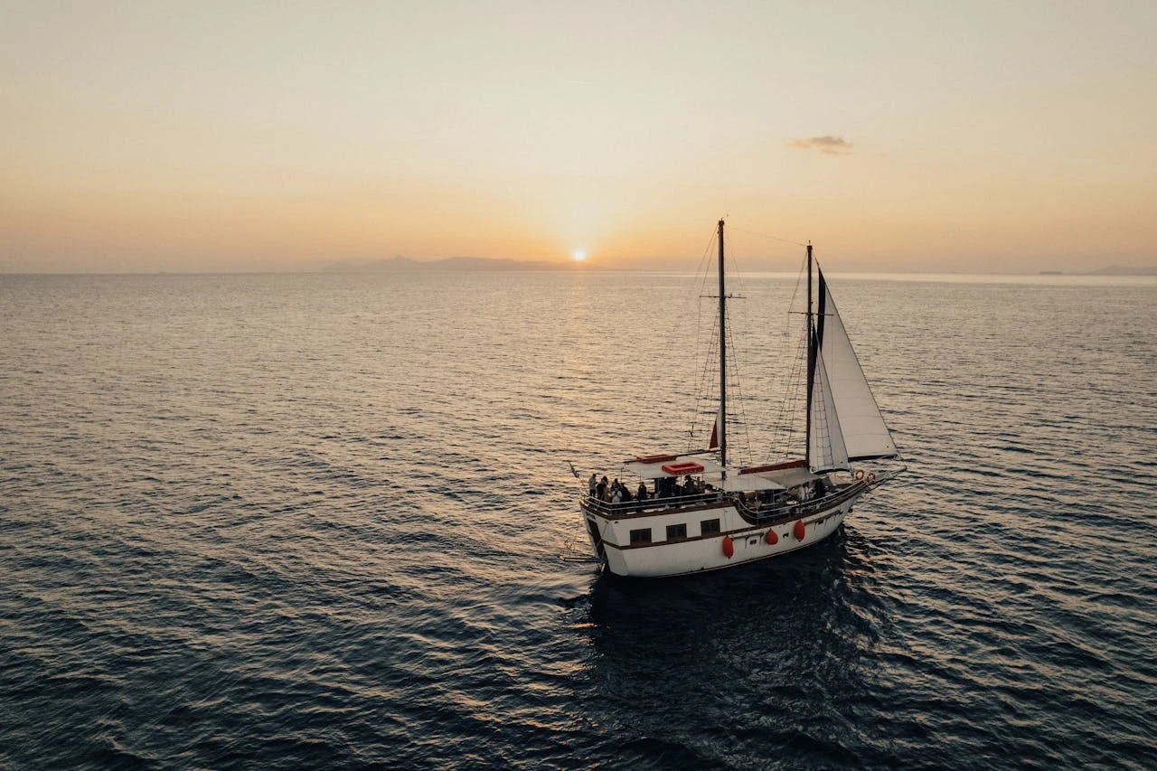 A ship rests in the sunset sea.